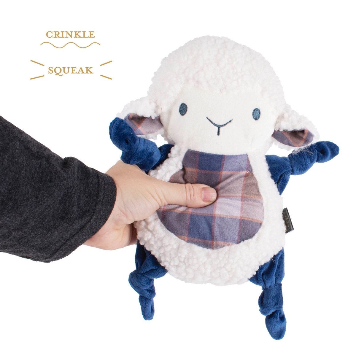 Plush sheep dog toy with crinkle and squeak features held by a hand on a white background.